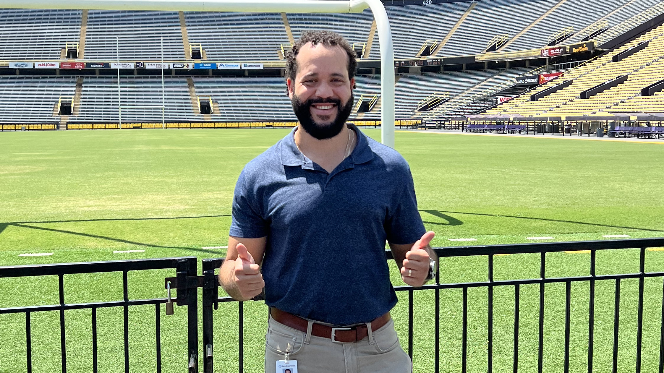 Dainon Miles stands in front of a football field.